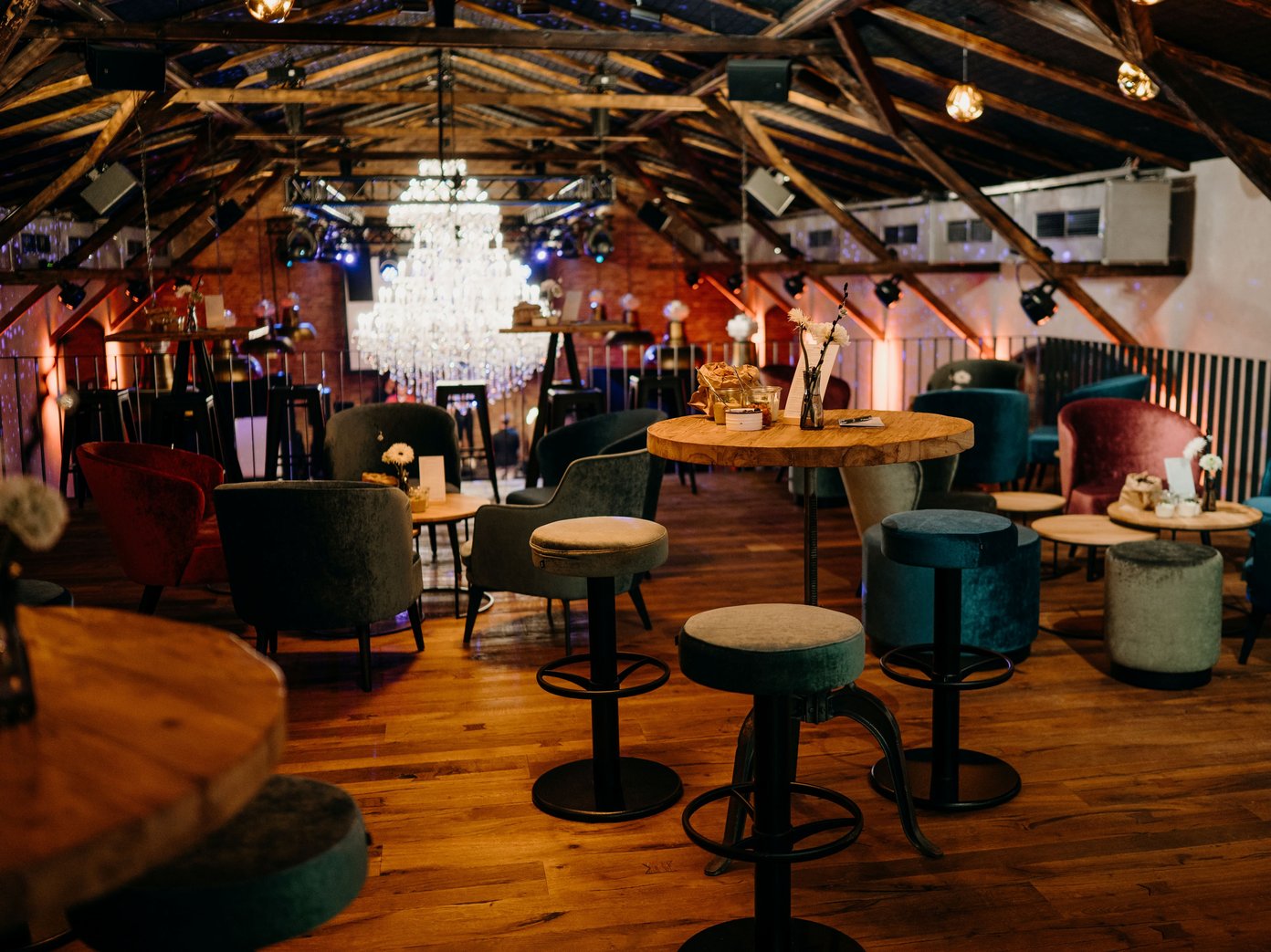 Empore mit Stehtischen Bunte Barhocker und ein Stehtisch auf einer Empore