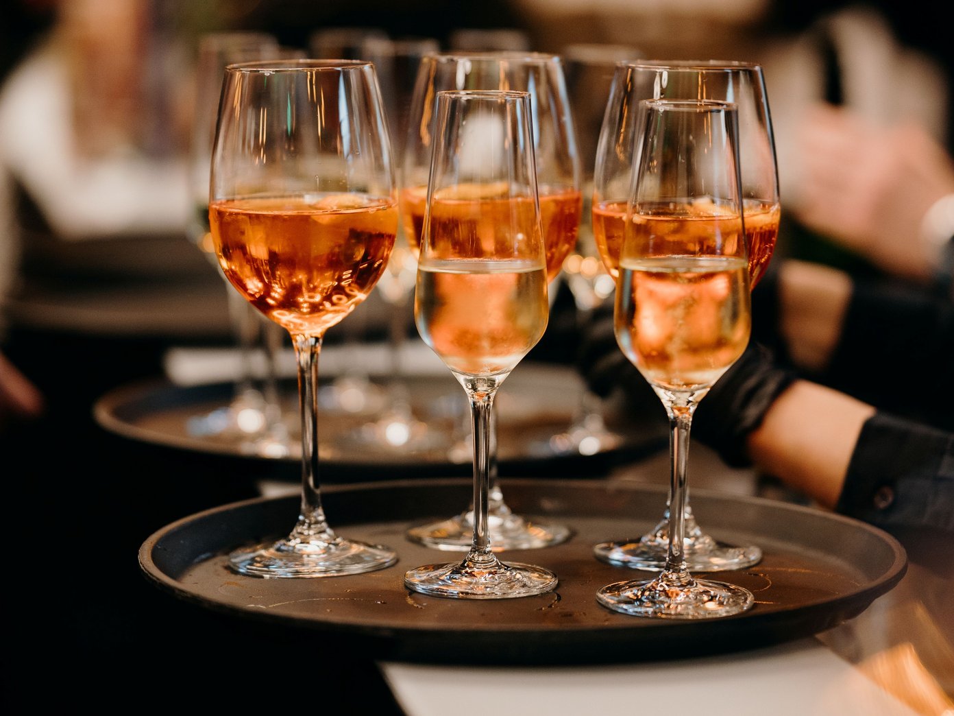 Ein Tablett mit drei Gläsern Aperol und zwei Gläsern Sekt