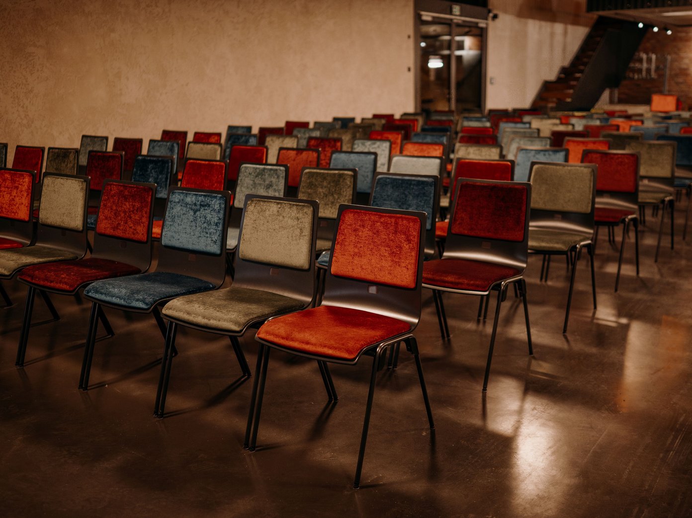 Reihen Bestuhlung Kulturschuppen bunte Stühle in einer Reihe im Kulturschuppen