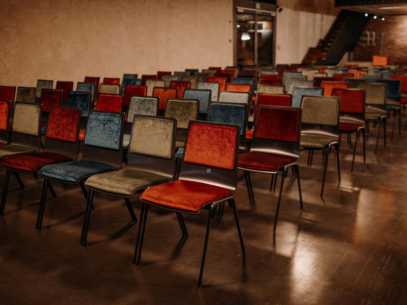 Reihen Bestuhlung Kulturschuppen bunte Stühle in einer Reihe im Kulturschuppen