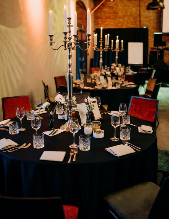Festlich eingedeckter Rundtisch mit großem Kerzenständer in der Mitte