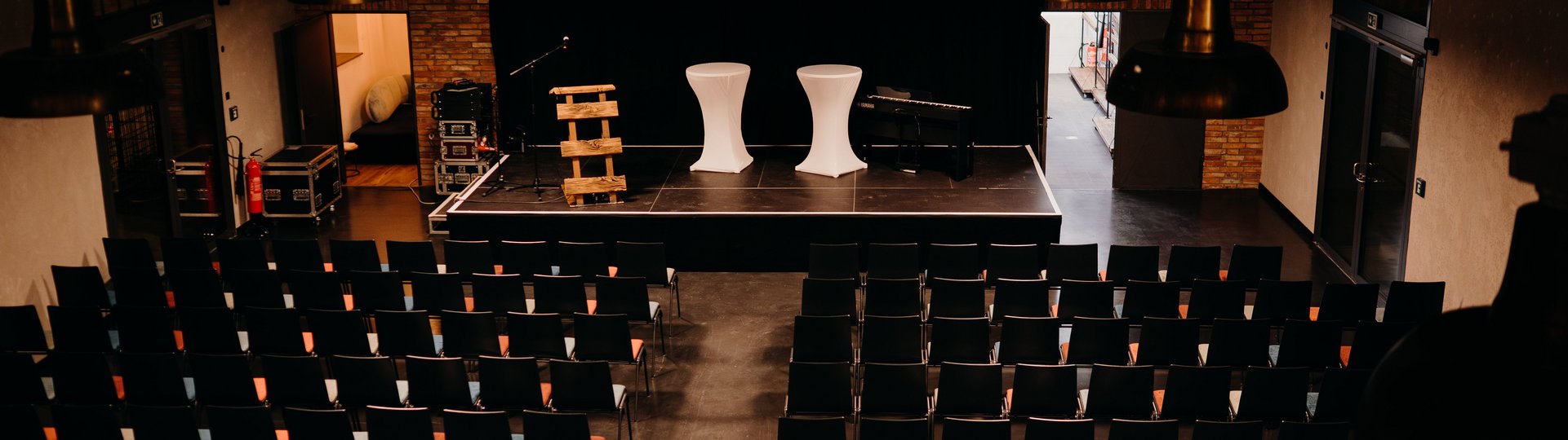 Veranstaltungsbestuhlung von oben fotografiert, Leinwand mit Schriftzug "Kulturschuppen" im Hintergrund