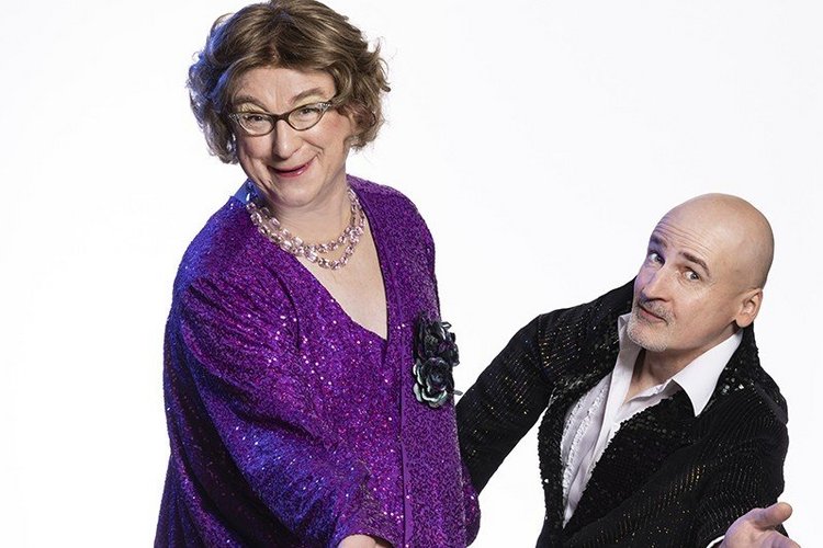 Mann im lila Glitzerkleid und Mann im Anzug