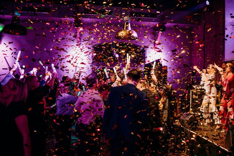 Goldener Konfettiregen auf viele tanzende Menschen