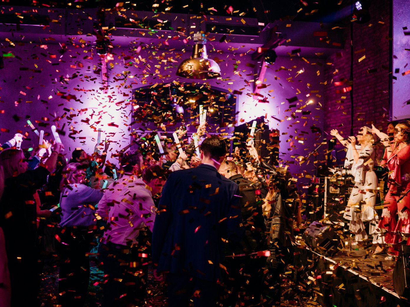 Goldener Konfettiregen auf viele tanzende Menschen