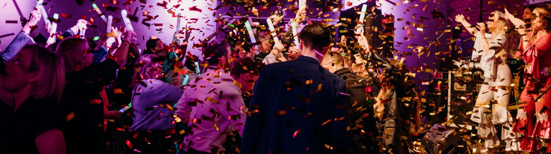 Goldener Konfettiregen auf viele tanzende Menschen