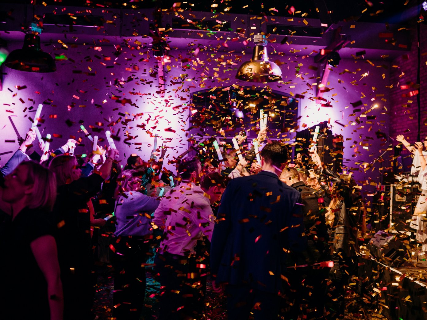 Goldener Konfettiregen auf viele tanzende Menschen