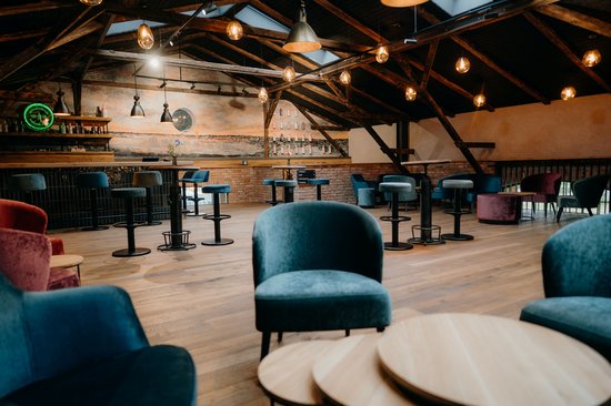 Empore aufgeräumt Gemütliche Sessel und Bartische sowie eine Bar im Hintergrund