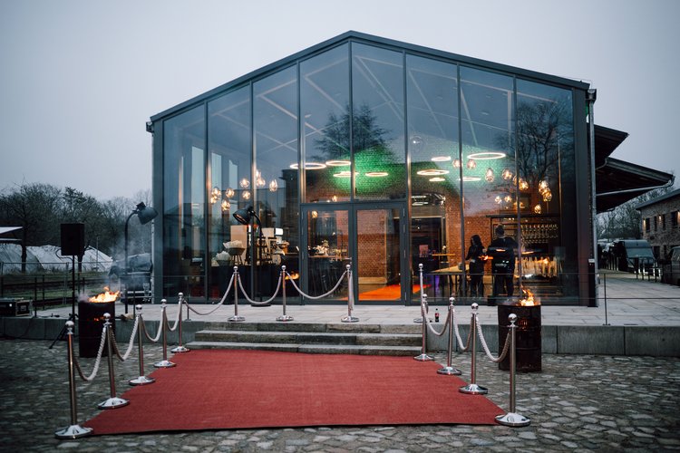 Roter Teppich und Kordeln vor einem Glaswintergarten