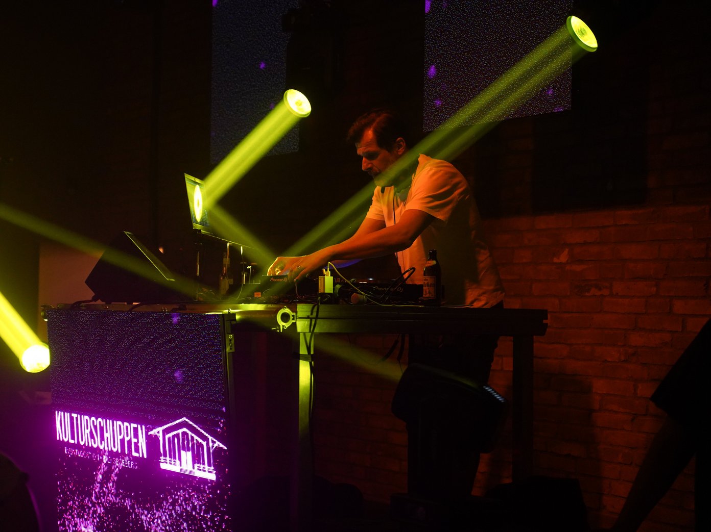 DJ am Pult DJ mit Diskobeleuchtung in Action