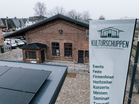 Kulturschuppen Rückseite Drohnenaufnahme mit Banner Kulturschuppen und dem Gebäude
